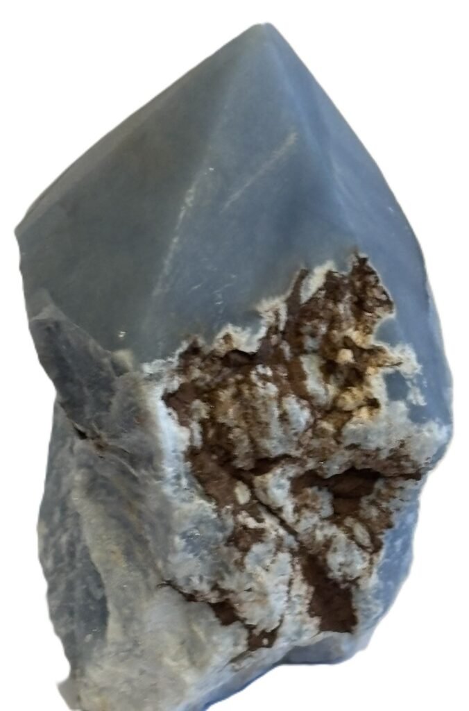 Natural rough angelite freeform with polished point 3 sians emporium Natural rough angelite freeform crystal with unpolished sides and a smooth polished blue point standing on a white background